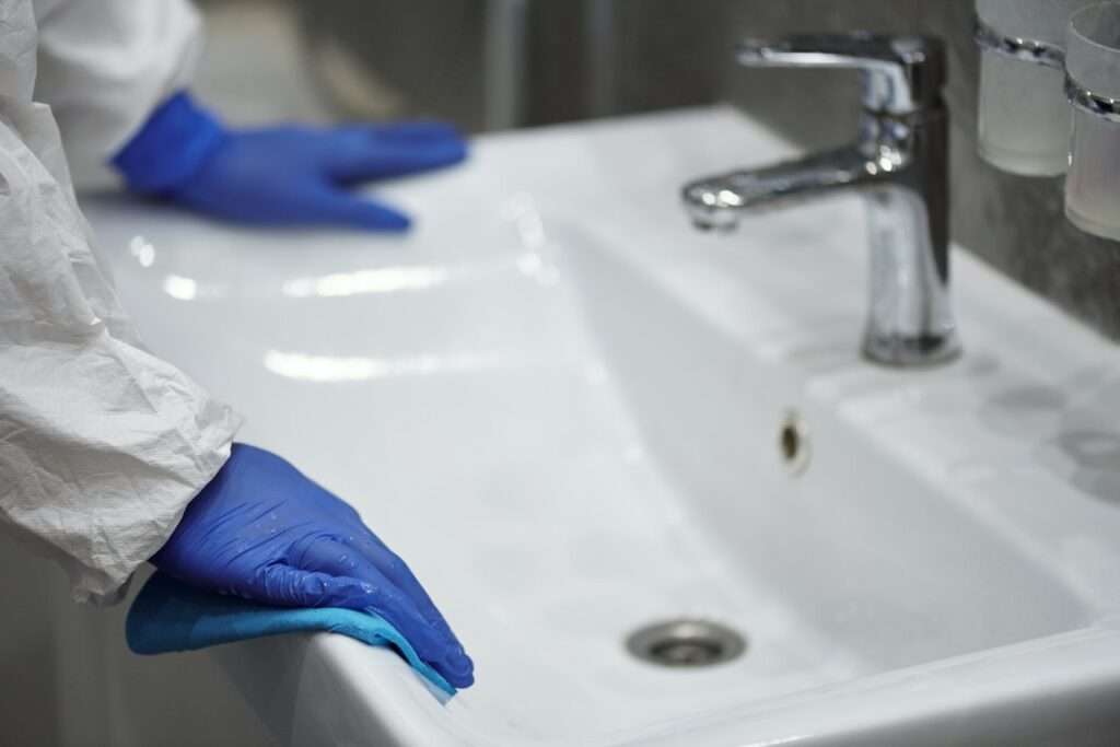 person wiping sink