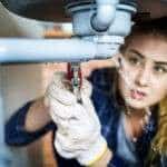 Woman fixing kitchen sink