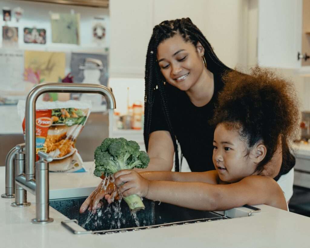 mother and daughter washing vegetables