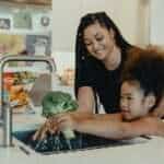 mother and daughter washing vegetables