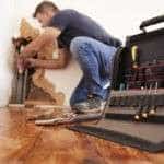 Middle aged man repairing burst pipe,plumbing, focus on foreground